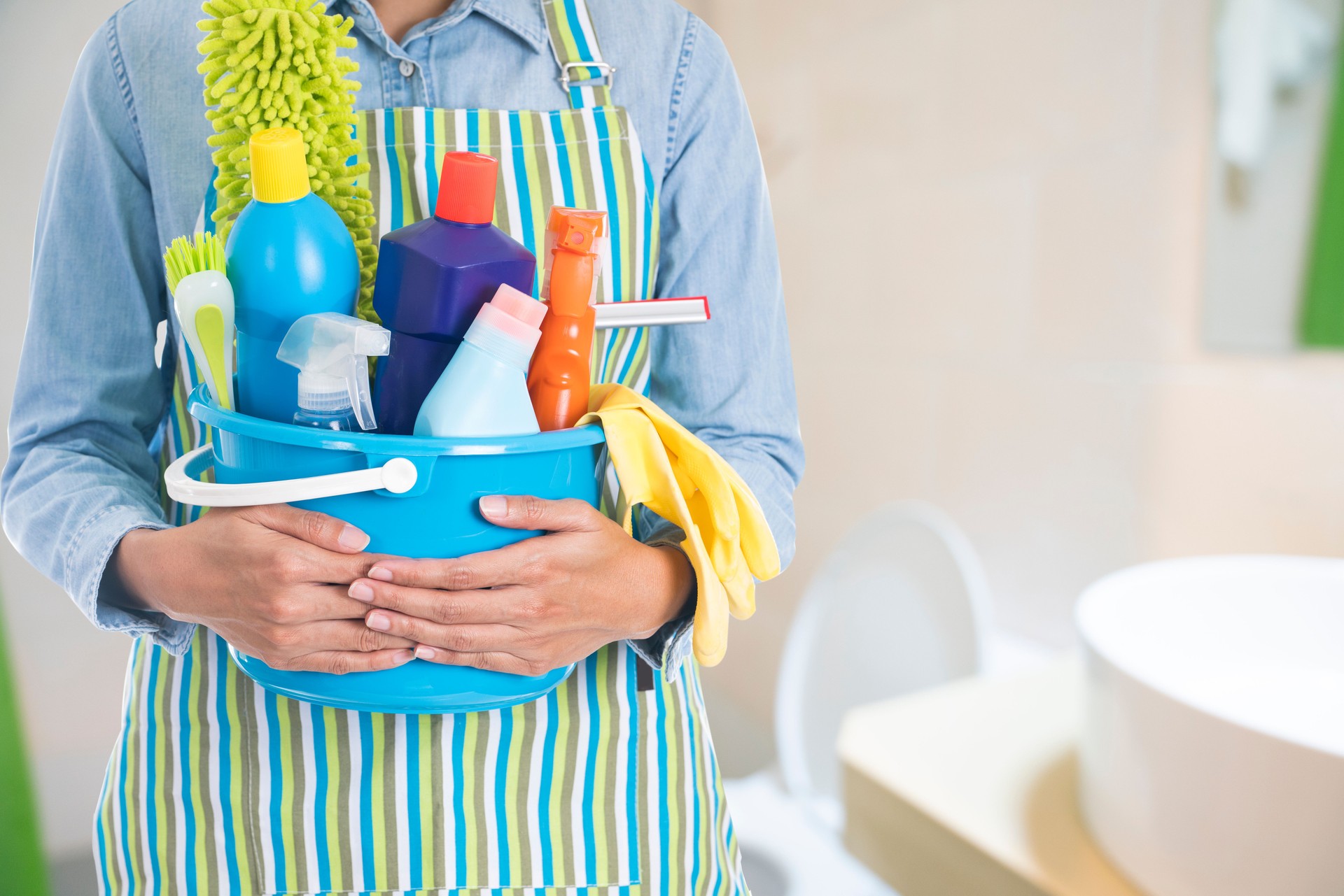 woman with cleaning equipment ready to clean house on bathroom or toilet blur background